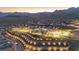 Beautiful aerial view of a hillside community with a clubhouse, pool, and stunning mountain backdrop at sunset at 912 Calluna Hills Ln, Las Vegas, NV 89138
