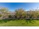 This backyard has desert landscaping and a green lawn with mountain views in the distance at 912 Calluna Hills Ln, Las Vegas, NV 89138