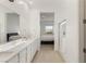 Bathroom featuring dual sinks, large mirror, glass shower, and bedroom view at 912 Calluna Hills Ln, Las Vegas, NV 89138
