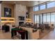 Bright lounge with modern fireplace, stylish lighting, and comfortable seating overlooking the landscape at 912 Calluna Hills Ln, Las Vegas, NV 89138