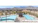 Community pool area showcasing two pools, lounge chairs, desert landscaping, and mountain views at 912 Calluna Hills Ln, Las Vegas, NV 89138