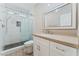 Bathroom featuring a white vanity and tiled shower with glass doors and gray pebble floor at 9130 Haddington Ln, Las Vegas, NV 89145