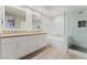 Elegant bathroom with double vanities, a soaking tub, and a separate glass-enclosed shower at 9130 Haddington Ln, Las Vegas, NV 89145