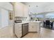 Bright kitchen area with white cabinets, stainless steel dishwasher, and a view of the dining area at 9130 Haddington Ln, Las Vegas, NV 89145