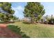 Community park with a grassy area, walking path, and mature trees providing shade at 9130 Haddington Ln, Las Vegas, NV 89145