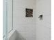 Close-up of the shower with gray pebble floor, a shelf in the wall, and light gray large tile surround at 9130 Haddington Ln, Las Vegas, NV 89145