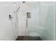 Light and bright shower with light gray tile surround, black pebble floor, and glass door at 9130 Haddington Ln, Las Vegas, NV 89145