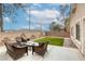 This home features a furnished backyard with an artificial grass lawn and privacy wall at 9432 Victory Garden Ave, Las Vegas, NV 89149