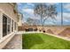 This home features a backyard with an artificial grass lawn, brick pathway, and privacy wall at 9432 Victory Garden Ave, Las Vegas, NV 89149