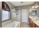 Modern bathroom with a soaking tub, tiled floors, a shower, and a double vanity sink at 9432 Victory Garden Ave, Las Vegas, NV 89149