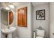 Powder room featuring a pedestal sink and cabinet, well-lit with a unique round mirror at 9432 Victory Garden Ave, Las Vegas, NV 89149