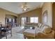 Spacious living room with a plush sectional sofa, large windows, and a ceiling fan at 9432 Victory Garden Ave, Las Vegas, NV 89149