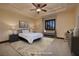 This virtually staged bedroom has a tray ceiling, cozy furniture, and bedside lamps at 10 Via Potenza Ct, Henderson, NV 89011