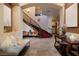 Elegant foyer with a grand staircase, seating area, decorative art, and tile flooring at 10 Via Potenza Ct, Henderson, NV 89011