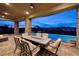 Inviting outdoor dining area with infinity pool, stunning city views, and comfortable seating under a covered patio at 10 Via Potenza Ct, Henderson, NV 89011