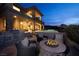 Charming outdoor patio with a cozy fire pit, built-in grill, lush landscaping, and inviting seating area at 10 Via Potenza Ct, Henderson, NV 89011
