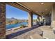 Covered patio with outdoor seating and infinity pool with stunning views of Lake Las Vegas at 10 Via Potenza Ct, Henderson, NV 89011