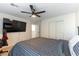 A bedroom featuring a bed, TV, ceiling fan, and closet with white doors at 1011 Pearl Marble Ave, North Las Vegas, NV 89081