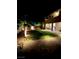 Beautifully lit backyard featuring lush green grass, mature trees, and brick pathways at 10173 Skye Saddle Ave, Las Vegas, NV 89166