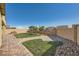 Lush backyard featuring green grass, brick pathways, and young palm trees at 10173 Skye Saddle Ave, Las Vegas, NV 89166