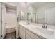 Bright bathroom featuring double sinks, modern fixtures, and a tub with tiled walls at 10173 Skye Saddle Ave, Las Vegas, NV 89166