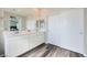 Bathroom featuring a dual sink vanity, a large mirror, and white cabinets at 10173 Skye Saddle Ave, Las Vegas, NV 89166