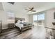 Primary bedroom with wood-look floors, a ceiling fan, and a sliding glass door at 10173 Skye Saddle Ave, Las Vegas, NV 89166