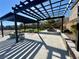 Covered pergola seating area in a well-maintained community park with green space and trees at 10173 Skye Saddle Ave, Las Vegas, NV 89166
