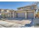 Charming two-story home featuring a tile roof, three-car garage, and brick-paved driveway at 10173 Skye Saddle Ave, Las Vegas, NV 89166