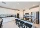 Stylish kitchen featuring white cabinets, stainless steel appliances, black granite countertops and a center island at 10173 Skye Saddle Ave, Las Vegas, NV 89166
