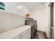 Convenient laundry room features modern washer and dryer, storage cabinets and laminate flooring at 10173 Skye Saddle Ave, Las Vegas, NV 89166