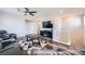 Open living room with modern furnishings, large TV, and staircase with white railings at 10173 Skye Saddle Ave, Las Vegas, NV 89166