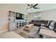 Comfortable living room featuring a ceiling fan, media center and plush sectional sofa at 10173 Skye Saddle Ave, Las Vegas, NV 89166