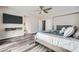 The primary bedroom features wood-look flooring, a ceiling fan, and a wall-mounted TV at 10173 Skye Saddle Ave, Las Vegas, NV 89166