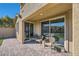 Relaxing covered brick patio with three comfortable woven chairs at 10173 Skye Saddle Ave, Las Vegas, NV 89166