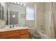 Bathroom with wooden cabinets, double sink, bathtub with shower and a large mirror at 10401 Sea Palms Ave, Las Vegas, NV 89134