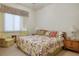 Bright bedroom featuring floral bedding, plush armchairs, and a large window with elegant valances at 10401 Sea Palms Ave, Las Vegas, NV 89134