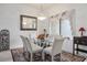 Bright dining room featuring a glass table, stylish chairs, elegant chandelier, and sunlit windows at 10401 Sea Palms Ave, Las Vegas, NV 89134