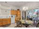 Bright kitchen with warm cabinets, a breakfast table, sliding door access to the patio, and neutral countertops at 10401 Sea Palms Ave, Las Vegas, NV 89134