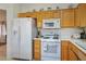 Functional kitchen with white appliances, including a refrigerator, microwave, and a gas range at 10401 Sea Palms Ave, Las Vegas, NV 89134