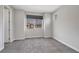 An empty bedroom with neutral carpet, a large window, and fresh white paint ready for decor at 10619 Carnes Ave, Las Vegas, NV 89166
