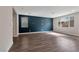 This expansive living area showcases modern wood-look floors and a stylish blue accent wall at 10619 Carnes Ave, Las Vegas, NV 89166