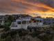 Beautiful hillside home at sunset, featuring modern architecture, a pool, and lush landscaping at 1484 Macdonald Ranch Dr, Henderson, NV 89012