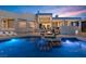 Backyard view with a gorgeous pool reflecting the lights of a spectacular sunset sky and the home's exterior lighting at 1484 Macdonald Ranch Dr, Henderson, NV 89012