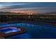 Beautiful pool and hot tub at twilight with city lights and mountain views in the background at 1484 Macdonald Ranch Dr, Henderson, NV 89012