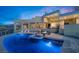 A luxurious pool and spa are the focal point of this backyard, offering breathtaking views of mountains and an evening sky at 1484 Macdonald Ranch Dr, Henderson, NV 89012