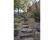 Stone steps and metal handrail winds through a landscaped area of gravel and boulders at 1484 Macdonald Ranch Dr, Henderson, NV 89012