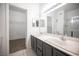 Bathroom featuring a double vanity, a large mirror, and an open doorway to a walk-in closet and a standup shower at 1704 N Jones Blvd, Las Vegas, NV 89108