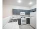 Clean kitchen featuring gray cabinets, white tile counters and appliances, with neutral flooring at 1704 N Jones Blvd, Las Vegas, NV 89108
