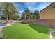 Large backyard featuring artificial turf, a brick wall, and mature trees at 2724 Monrovia Dr, Las Vegas, NV 89117